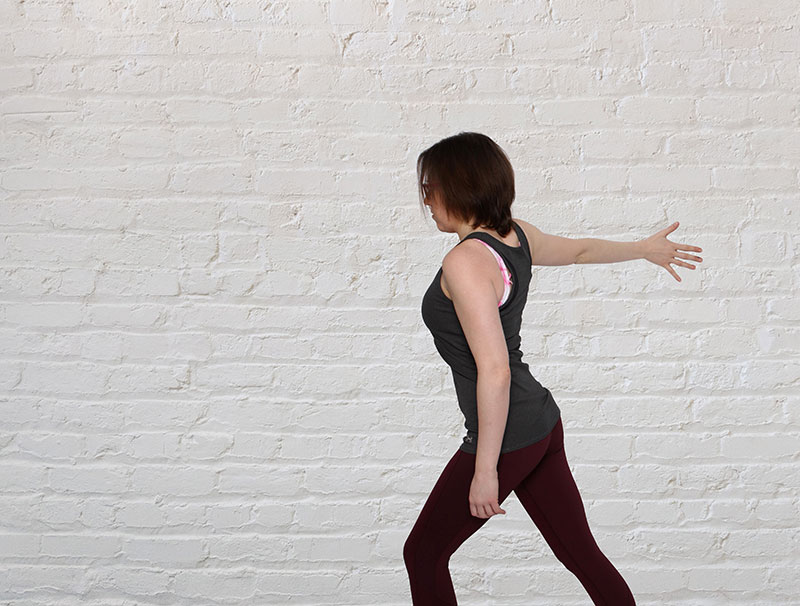 women on wall doing arms stretches